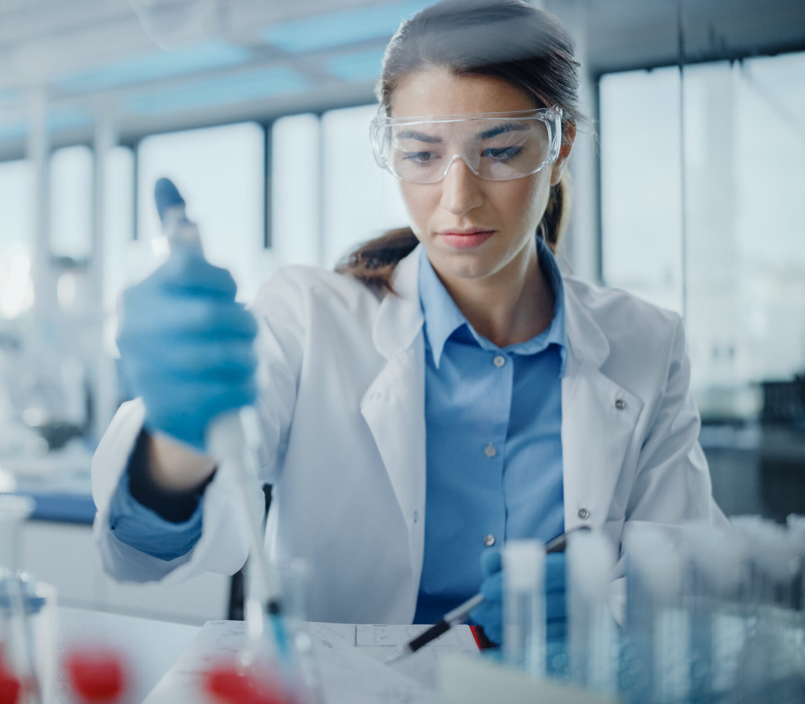 Medical Research Laboratory: Portrait of a Beautiful Female Scientist in Goggles Using Micro Pipette for Test Analysis. Advanced Scientific Lab for Medicine, Biotechnology, Microbiology Development